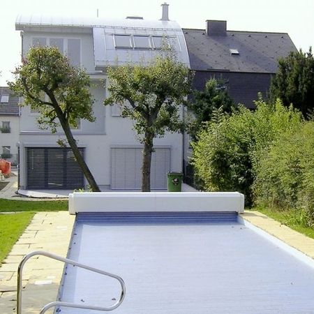 Modernes Haus mit einem abgedecktem Pool im Vordergrund
