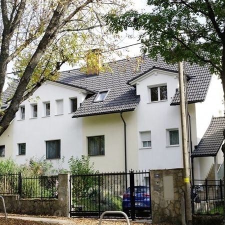 Schräg fotografiertes Haus mit Bäumen im Vordergrund