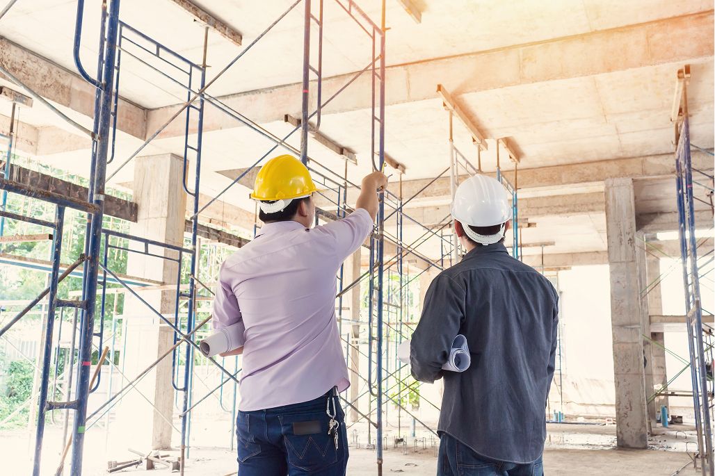 Zwei Menschen mit Helmen auf einer Baustelle